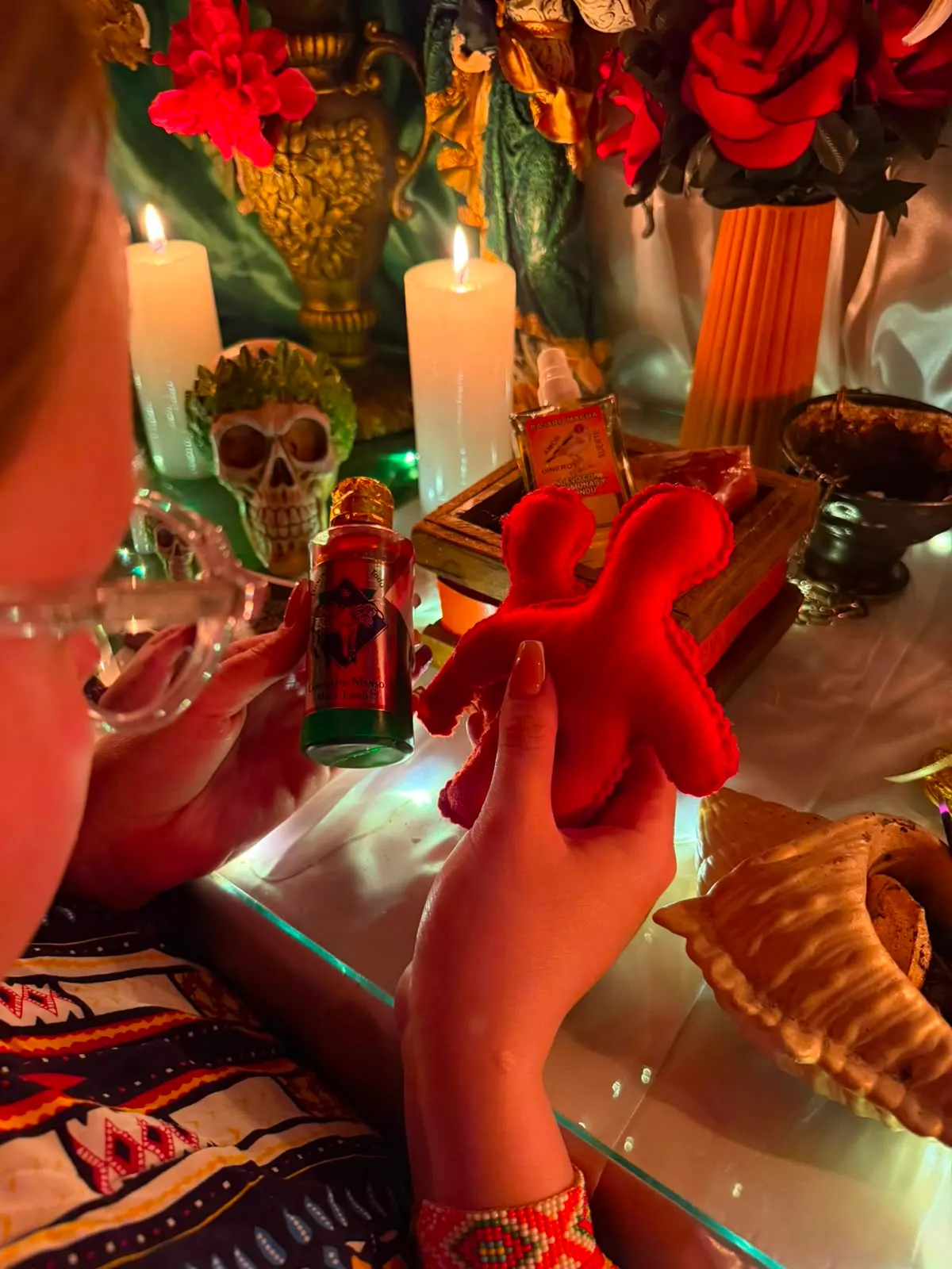 Preparación de un trabajo con esencias, una figura de tela y velas encendidas frente al altar